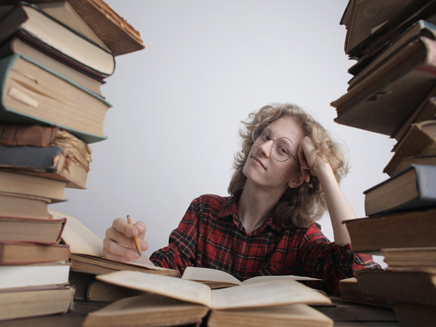 Woman in mid of stack of books