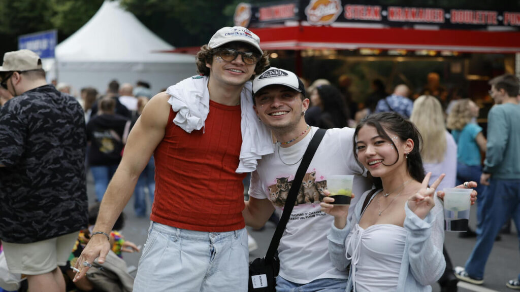 Group of friends laughing and enjoying a vibrant festival in Berlin, Germany