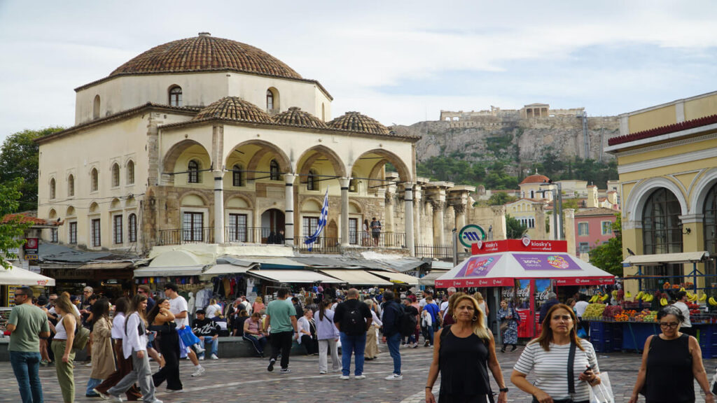 Busy marketplace in Athens with the Acropolis in the background, capturing everyday life