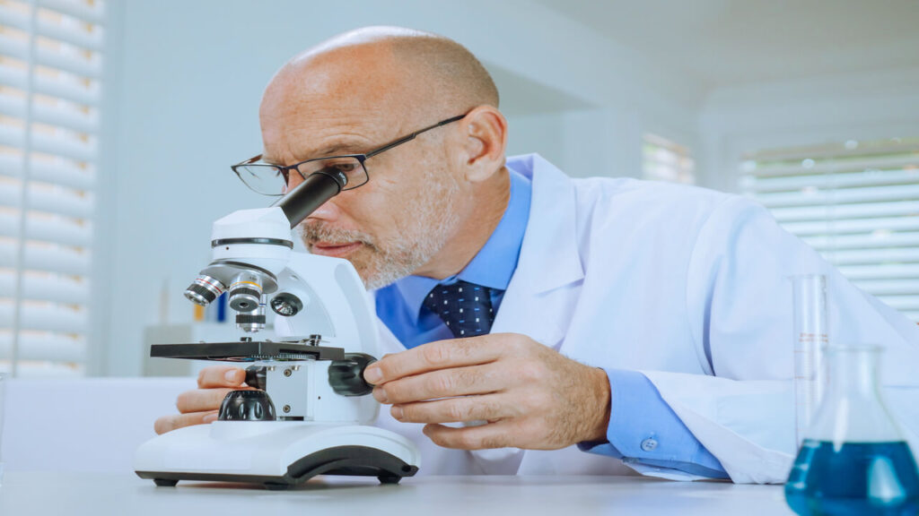 Scientist examining samples through a microscope in a modern laboratory setting