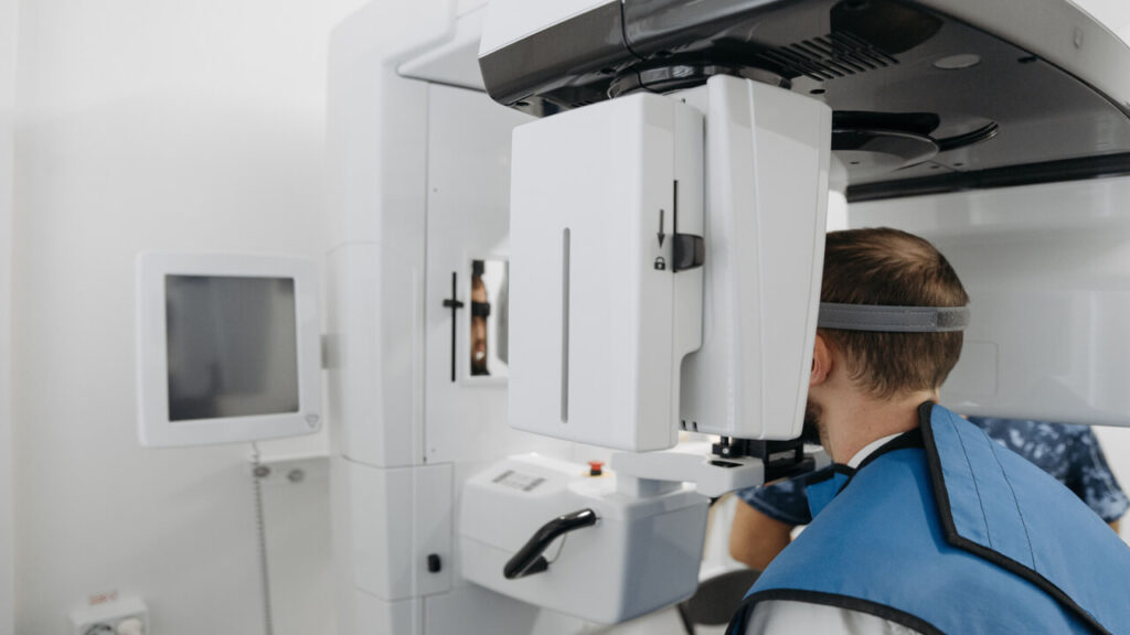 A patient undergoing a dental panoramic X-ray scan in a clinic setting
